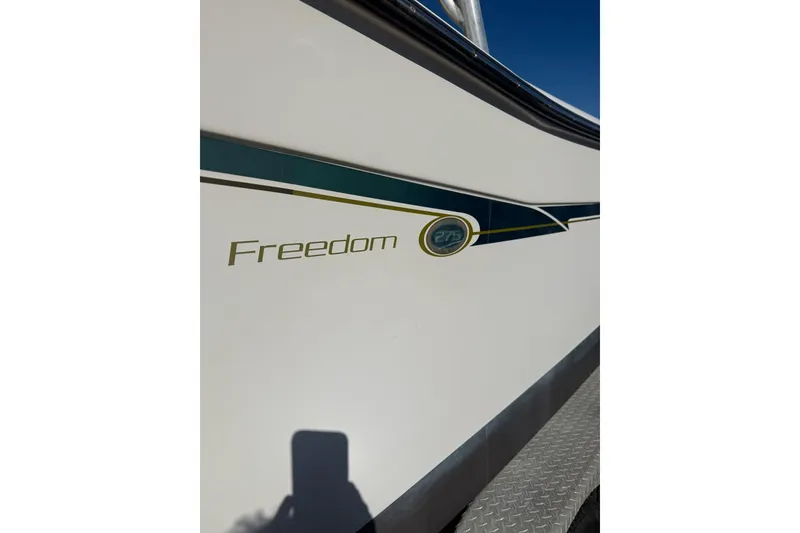 Slide: The Image of 2011 Grady-White Freedom 275 boat side view with logo and design details. - 9