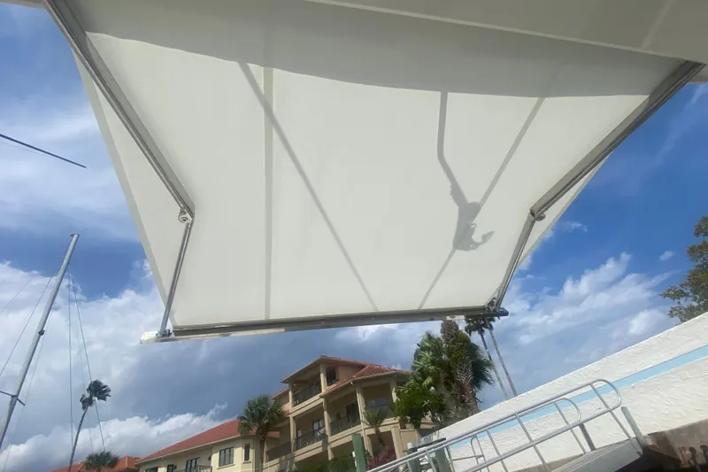 Slide: The Image of 2021 Pursuit OS 355 Offshore boat canopy with scenic marina backdrop. - 12