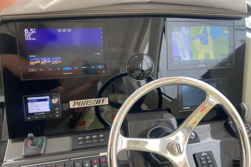 Slide: The Image of Dashboard of 2021 Pursuit OS 355 Offshore with Garmin displays and steering wheel. - 16