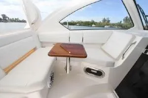 Slide: The Image of 2021 Pursuit OS 355 Offshore boat interior with seating and wooden table. - 26