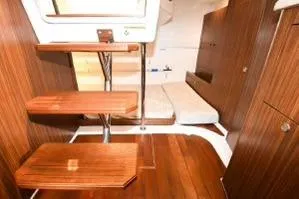 Slide: The Image of 2021 Pursuit OS 355 Offshore cabin interior with wooden steps and cozy sleeping area. - 28
