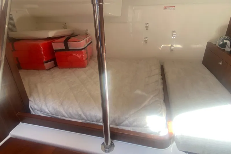 Slide: The Image of 2021 Pursuit OS 355 Offshore cabin with life jackets on bed. - 29