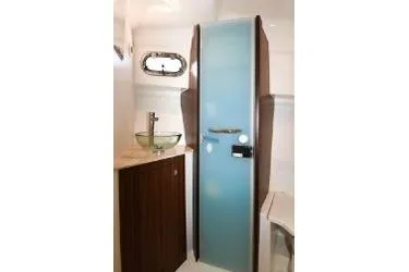 Slide: The Image of 2021 Pursuit OS 355 Offshore bathroom with modern sink and frosted glass door. - 32