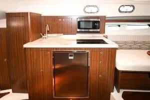 Slide: The Image of 2021 Pursuit OS 355 Offshore yacht kitchen with wood cabinetry and modern appliances. - 35