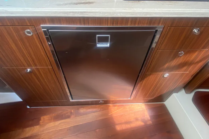 Slide: The Image of 2021 Pursuit OS 355 Offshore interior with stainless steel fridge and wooden cabinetry. - 36