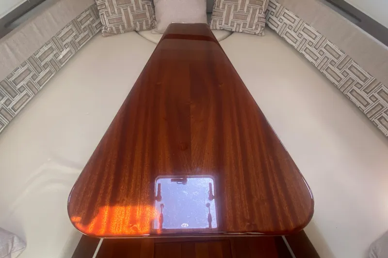 Slide: The Image of 2021 Pursuit OS 355 Offshore cabin with polished wooden table and patterned cushions. - 42