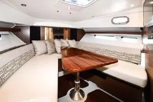 Slide: The Image of 2021 Pursuit OS 355 Offshore cabin with elegant seating and wooden table. - 44
