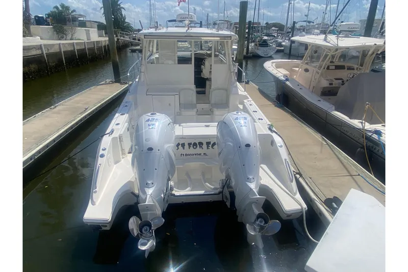 Slide: The Image of 2021 Pursuit OS 355 Offshore boat docked with twin outboard engines. - 49