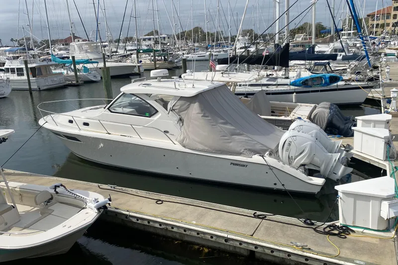 Slide: The Image of 2021 Pursuit OS 355 Offshore boat docked in a marina with other vessels. - 52