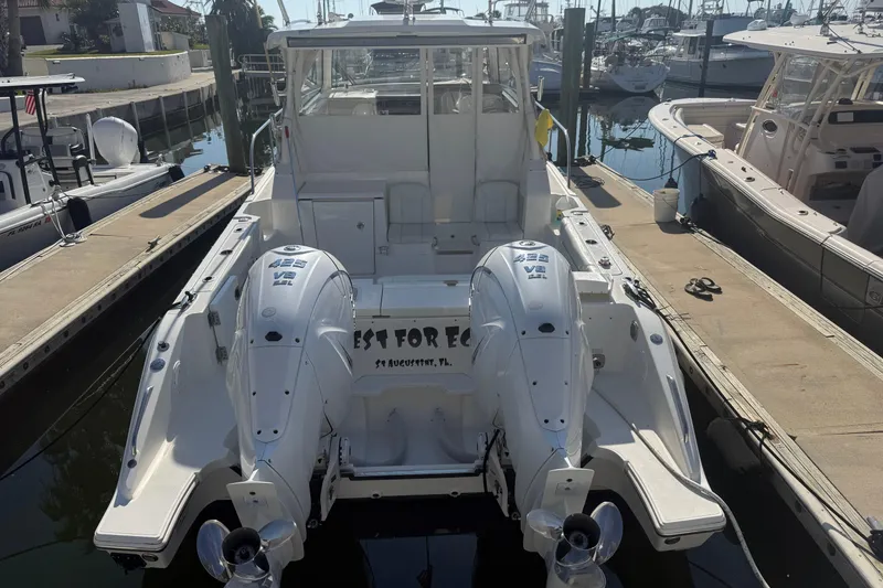 Slide: The Image of 2021 Pursuit OS 355 Offshore boat docked with twin outboard engines. - 55