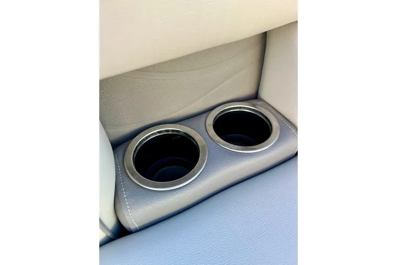 Slide: The Image of 2021 SMOKERCRAFT EX20C boat interior with dual cup holders in beige upholstery. - 25