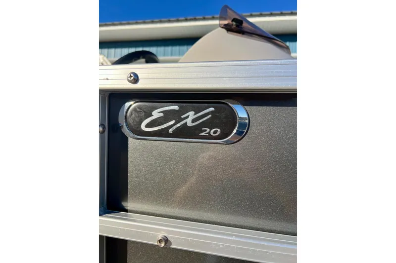Slide: The Image of 2021 SMOKERCRAFT EX20C boat emblem with metallic finish under blue sky. - 6
