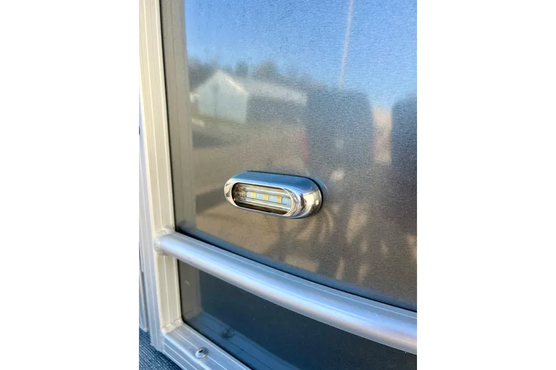 Slide: The Image of 2021 SMOKERCRAFT EX20C pontoon boat parked outside blue garage. - 62