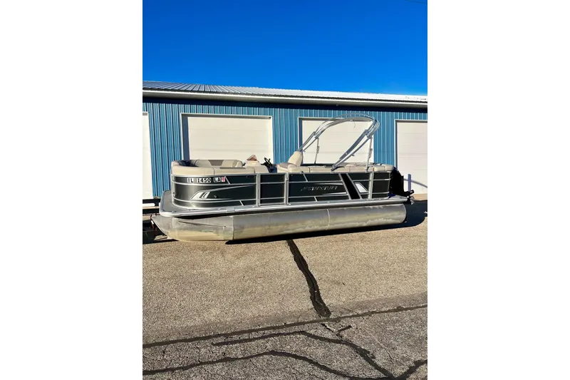 Slide: The Image of 2021 SMOKERCRAFT EX20C pontoon boat parked outside blue building. - 63