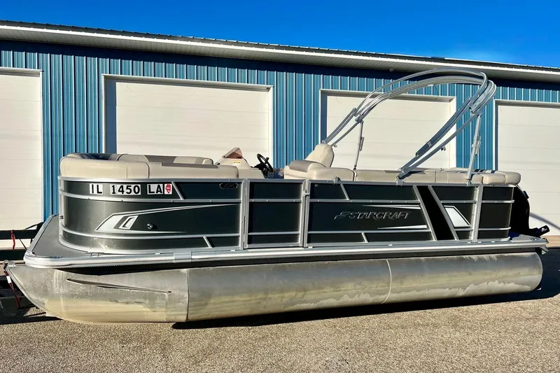 Slide: The Image of 2021 SMOKERCRAFT EX20C pontoon boat parked outside blue building. - 64