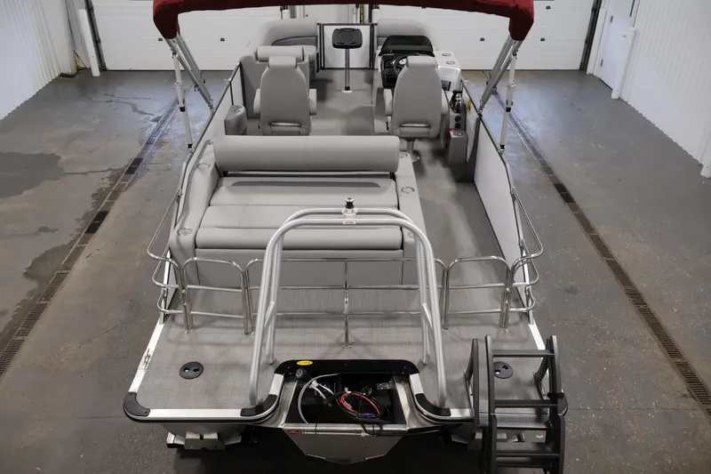 Slide: The Image of 2026 Bentley Pontoons 220 SWINGBACK with gray seating and red canopy in a garage. - 9