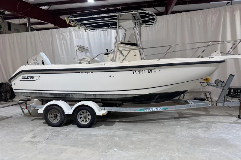 The Image of 2000 Boston Whaler 21 Outrage boat on trailer in indoor storage. - 1