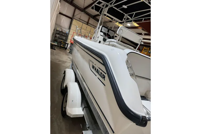 Slide: The Image of 2000 Boston Whaler 21 Outrage boat on trailer in a warehouse. - 18