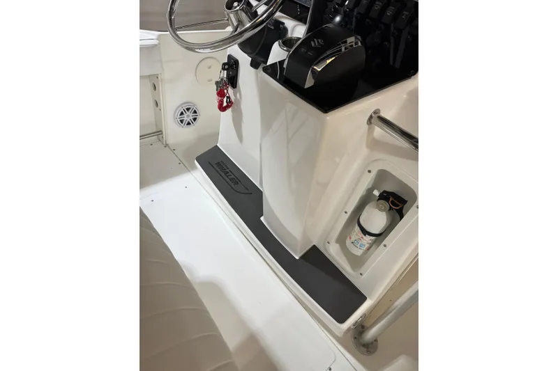 Slide: The Image of Interior of 2000 Boston Whaler 21 Outrage boat, featuring steering console and safety equipment. - 7