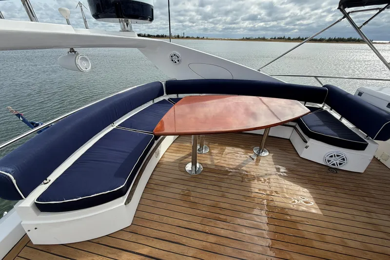 Slide: The Image of Sunseeker 75 Sport Yacht 2005 deck with blue cushioned seating and wooden table. - 16