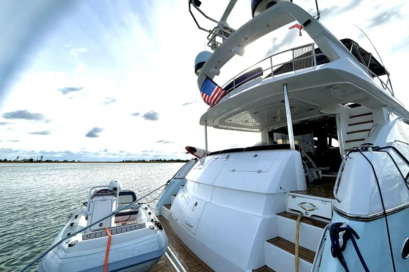 Slide: The Image of Sunseeker 75 Sport Yacht 2005 docked with tender, featuring spacious deck and modern design. - 2