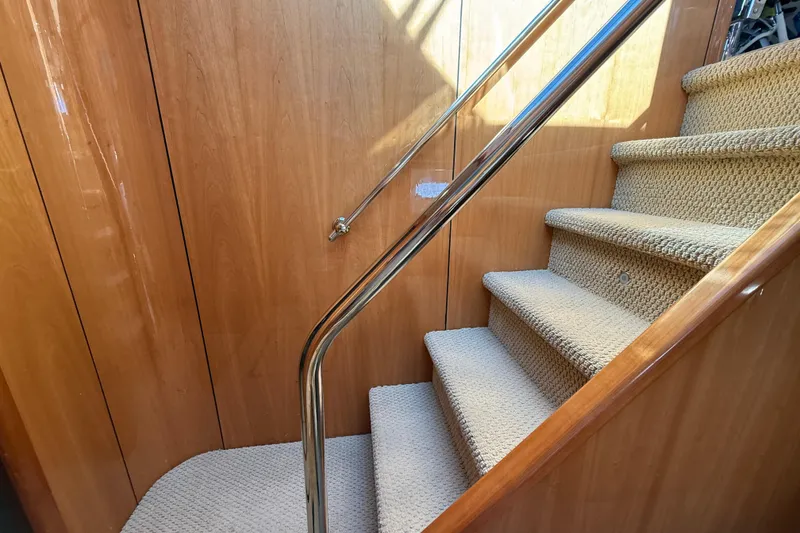 Slide: The Image of Carpeted stairs with wooden paneling and metal railing on a 2005 Sunseeker 75 Sport Yacht. - 42