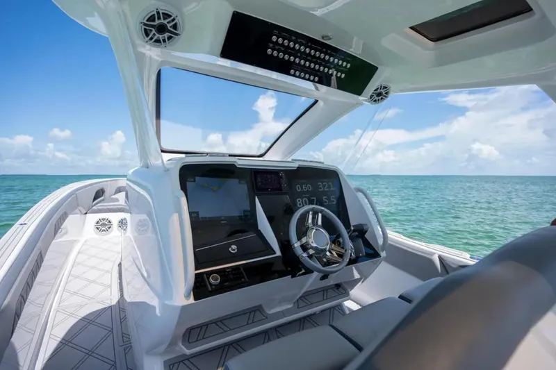 Slide: The Image of 2024 Deep Impact 369 Sport boat cockpit with modern controls, steering wheel, and ocean view. - 15