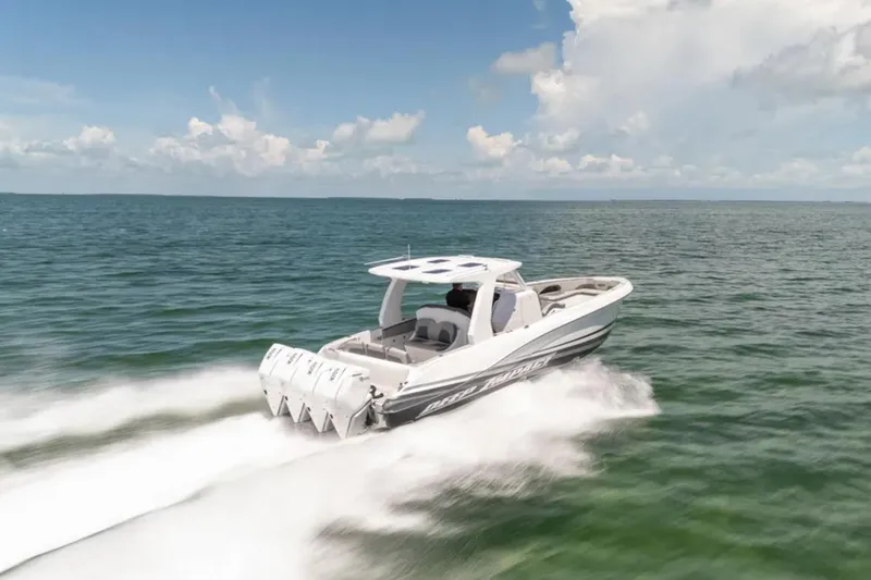 Slide: The Image of 2024 Deep Impact 369 Sport boat speeding on open water under a clear sky. - 24