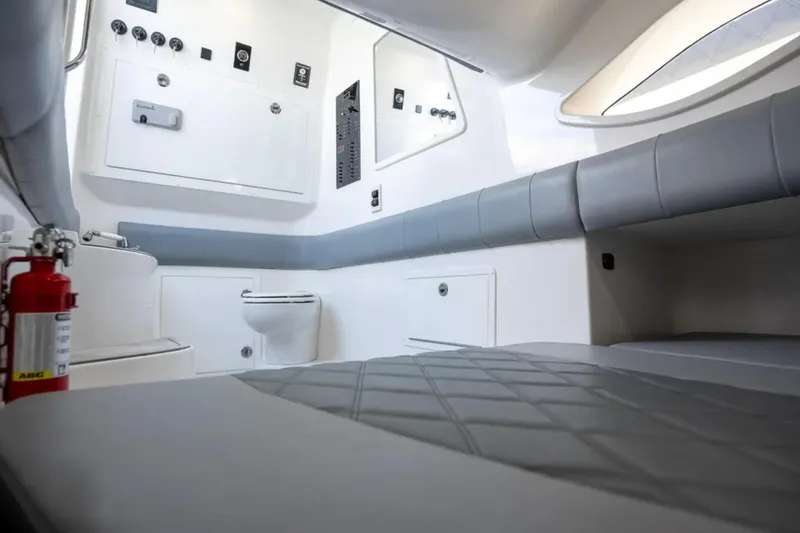 Slide: The Image of Interior of 2024 Deep Impact 369 Sport boat, featuring seating, toilet, and fire extinguisher. - 32