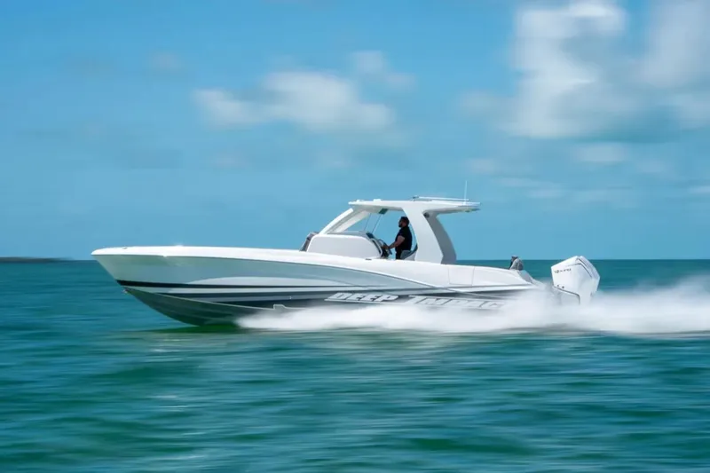 Slide: The Image of 2024 Deep Impact 369 Sport boat speeding on open water under clear blue sky. - 35