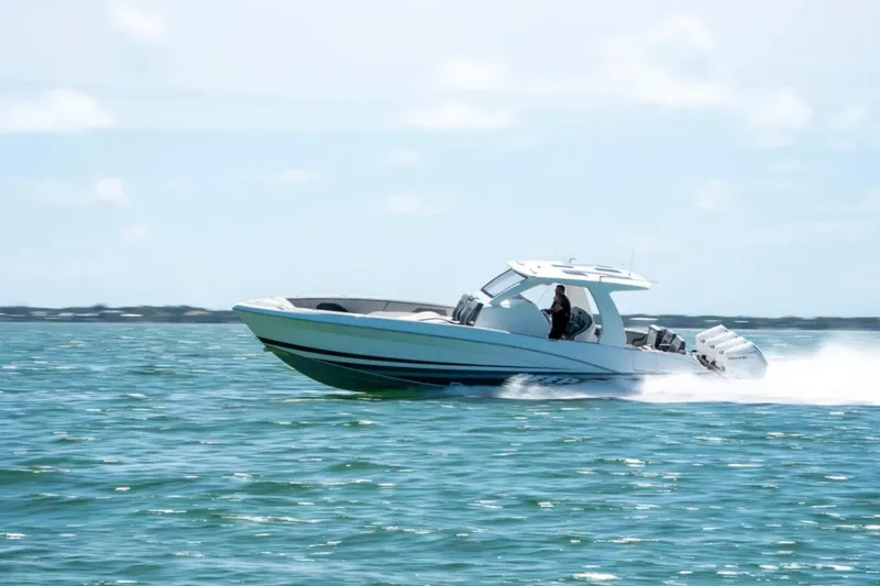 Slide: The Image of 2024 Deep Impact 369 Sport boat speeding on open water under clear skies. - 37