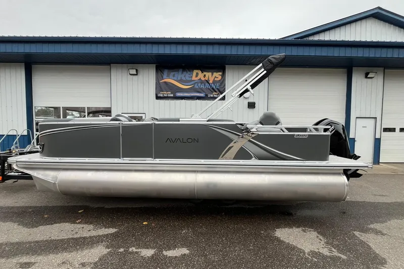The Image of 2025 Avalon LSZ Rear Fish pontoon boat parked outside a marine shop. - 1