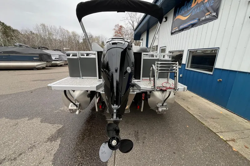 Slide: The Image of 2025 Avalon LSZ Rear Fish boat with outboard motor, parked at a marina. - 3