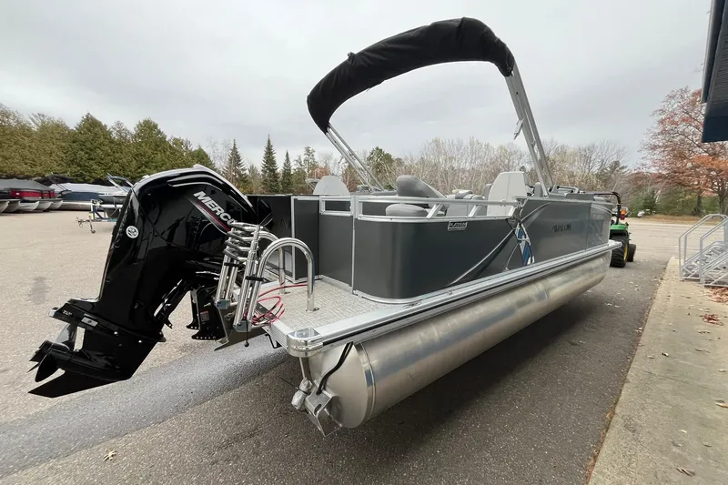 Slide: The Image of 2025 Avalon LSZ Rear Fish pontoon boat with Mercury outboard motor, parked outdoors. - 4