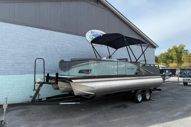 The Image of 2026 Avalon 2385 LSZ Entertainer pontoon boat on trailer, parked outside a building. - 0
