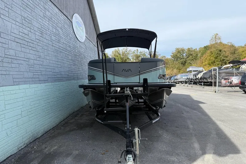 Slide: The Image of 2026 Avalon 2385 LSZ Entertainer pontoon boat on trailer, parked beside a building. - 3