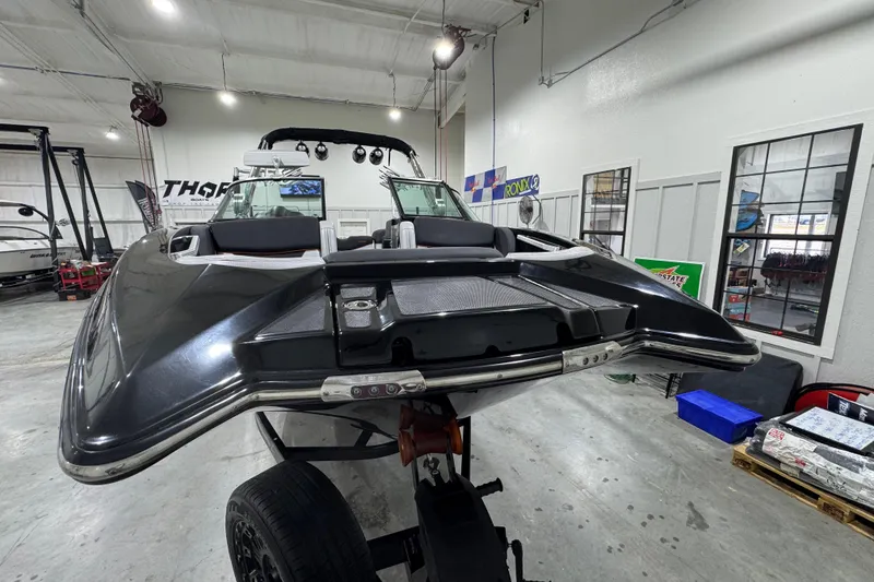 Slide: The Image of 2017 MasterCraft X23 boat in showroom, sleek design, black exterior, on trailer. - 10