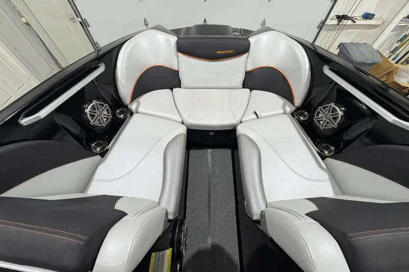 Slide: The Image of 2017 MasterCraft X23 boat interior with white and black seating, featuring premium speakers. - 16