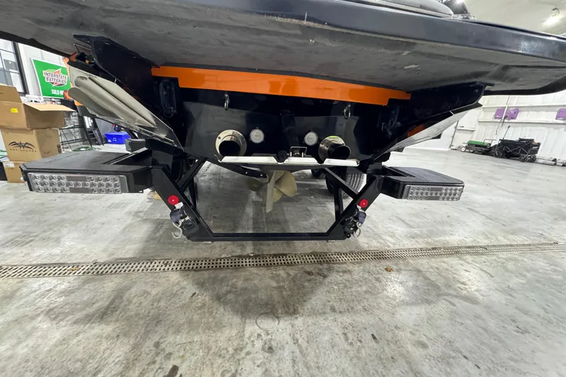 Slide: The Image of 2017 MasterCraft X23 boat underside with propeller and LED lights in a garage setting. - 4