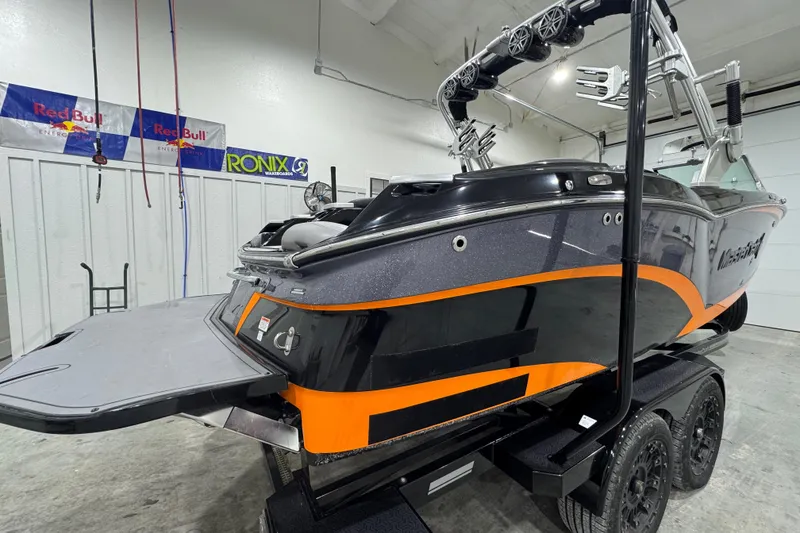 Slide: The Image of 2017 MasterCraft X23 boat with orange accents on a trailer in a garage. - 5