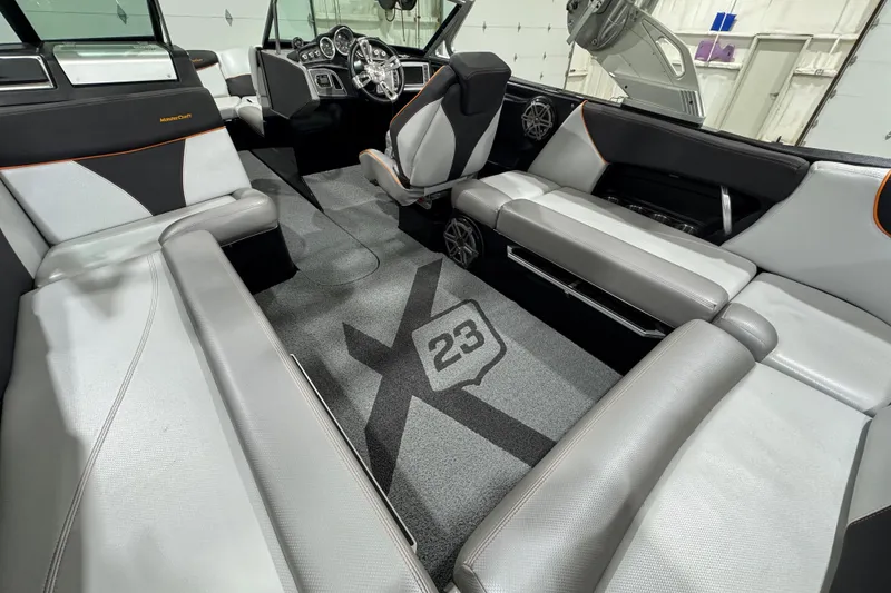 Slide: The Image of 2017 MasterCraft X23 boat interior with sleek seating and modern dashboard design. - 7