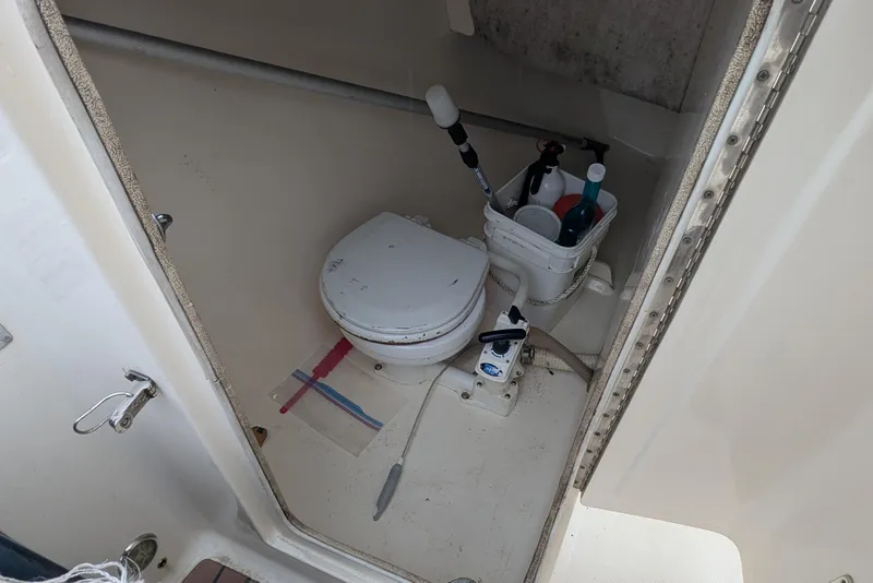 Slide: The Image of 2009 Scout 245 Dorado boat bathroom with toilet and cleaning supplies. - 15