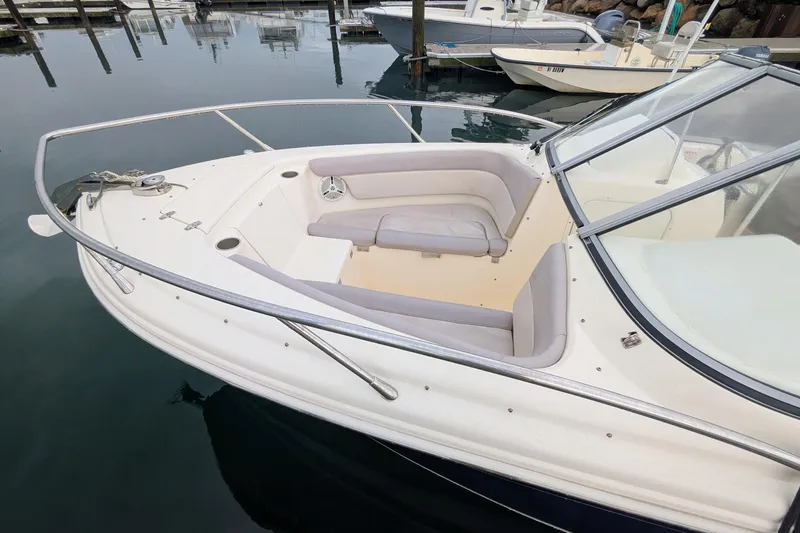 Slide: The Image of 2009 Scout 245 Dorado boat with cushioned seating, docked in a marina. - 4