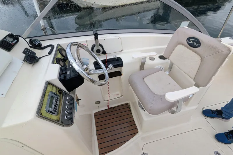 Slide: The Image of 2009 Scout 245 Dorado boat cockpit with steering wheel and control panel. - 6