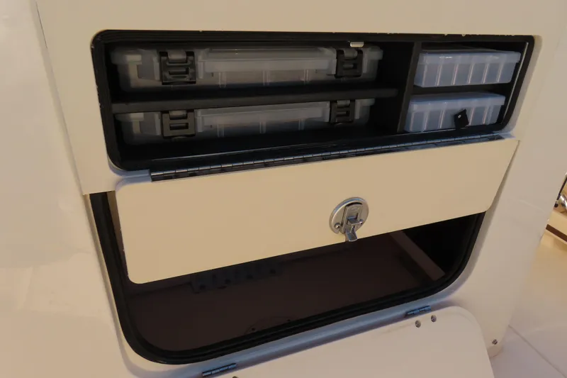 Slide: The Image of Storage compartment on a 2019 Grady-White Fisherman 257 boat with tackle boxes. - 27