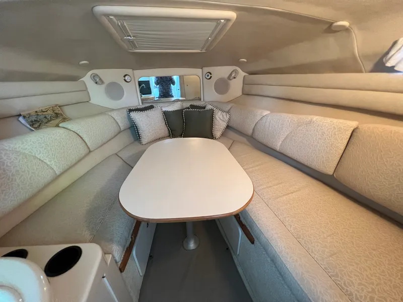 Slide: The Image of Interior of a 2001 Sea Ray 260 Sundancer with cozy seating and a central table. - 11