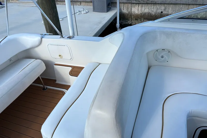 Slide: The Image of Interior view of a 2001 Sea Ray 260 Sundancer boat with white seating and wood flooring. - 5