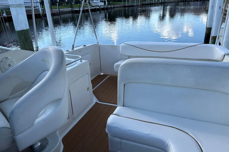 Slide: The Image of 2001 Sea Ray 260 Sundancer boat interior with white seating and wood flooring. - 6