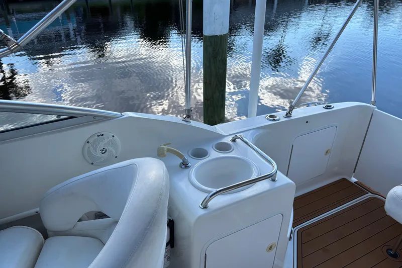 Slide: The Image of 2001 Sea Ray 260 Sundancer boat interior with seating and cup holders by the water. - 7