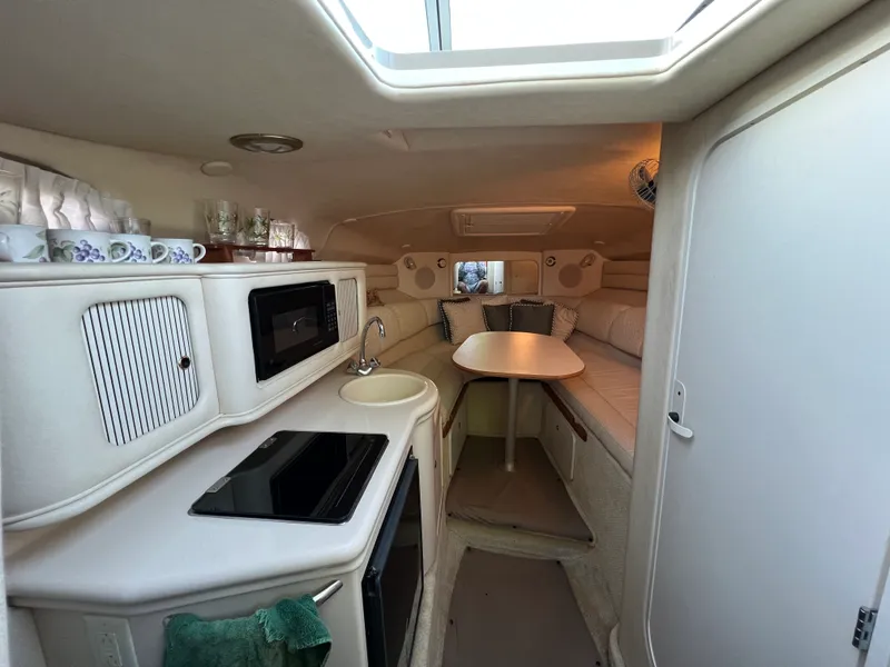 Slide: The Image of Interior of 2001 Sea Ray 260 Sundancer boat with kitchenette and seating area. - 9